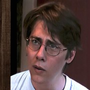 Young man with glasses and floppy dark hair